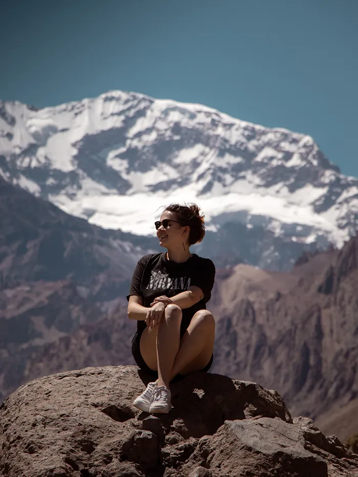 Girl sitting on a rock in front of Aconcagua